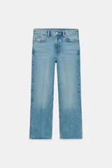 Jeans cropped flare de tiro medio color celeste, confeccionados en denim con efecto lavado. Presentan diseño de cinco bolsillos, trabillas para cinto, raya planchada al frente y bajo desflecado con terminación evasé. Cuenta con cierre frontal de cremallera y botón metálico.