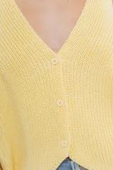 Chaleco celeste de punto con escote en V y cierre frontal con botones. Tejido calado y corte holgado.