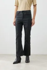 Pantalón de jean negro, tiro alto, corte cropped y botamanga acampanada.