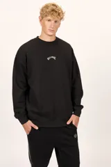 Buzo Billabong Arch Over Crew de color negro, con cuello redondo y diseño de mangas caídas. Presenta un pequeño bordado en hilo blanco en el centro del pecho con el nombre de la marca en tipografía arqueada.