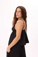 Top color amarillo pálido con breteles finos, escote en V profundo y ajuste frontal con botones.