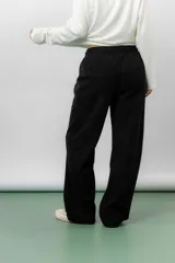 Pantalón de corte relajado y pierna recta, confeccionado en tejido tipo corderoy liviano. Presenta cintura elastizada con cordón ajustable y diseño de silueta amplia.