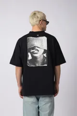 Remera de corte oversize confeccionada en algodón premium de alto gramaje. Presenta un diseño minimalista con un pequeño logo bordado en el centro del pecho y un parche estampado en la espalda. Posee cuello redondo y mangas cortas con caída relajada.