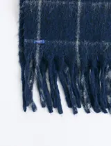 Bufanda de estilo escocés con textura suave, diseño a cuadros en tonos azul y verde, con flecos en los extremos.