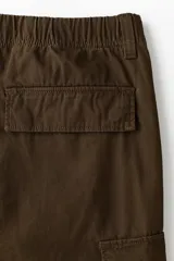 Pantalón cargo de lona de algodón con bolsillos laterales tipo cargo, bolsillos traseros con solapa y pliegues en las rodillas. Presenta cierre con botón y ajuste en la cintura.