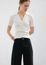 Pantalón de jean negro de corte recto y tiro alto, con diseño de pierna ancha y terminaciones deshilachadas en el ruedo.