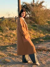 Saco largo color marrón, tejido en lana con trenzas tejidas y bolsillos de cuero.