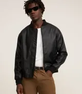 Campera bomber para hombre confeccionada en material sintético (PU) color negro. Presenta cuello alto, cierre frontal de cremallera, mangas largas con puños acanalados y bajo también acanalado.