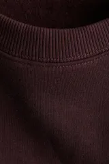 Buzo de tejido de punto color borgoña con cuello redondo y diseño estampado en el frente con el texto 'BEAU PARIS 1995' en tipografía arqueada blanca.