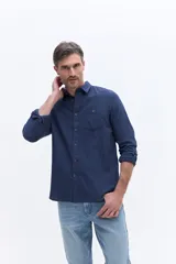Camisa de manga larga confeccionada en viyela de algodón, con cierre frontal de botones, cuello clásico y bolsillo aplicado en el pecho.