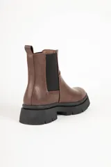 Bota Chelsea marrón de símil cuero con elásticos laterales negros y suela track negra.