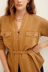 Kimono de algodón color tostado, de manga larga, con bolsillos frontales con solapa y detalle de cinto incorporado.