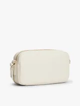 Cartera tipo bandolera de diseño compacto y líneas redondeadas, marca Tommy Hilfiger. Está confeccionada en poliuretano con acabado liso de color beige, cierre de cremallera y cuenta con una inscripción de la marca en bajo relieve en la parte delantera. Incluye una correa cruzada ajustable de jacquard tonal con el logo de la marca.