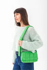 Cartera tipo bandolera acolchada de color verde brillante, con correa ancha y ajustable con hebilla metálica.