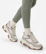 Championes chunky Satinato, color gris con detalles blancos y suela gruesa marrón. Confeccionados en poliuretano con inserciones de malla, cordones y tirador trasero.