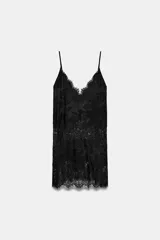 Top largo confeccionado en tejido de encaje con escote en pico y tirantes finos. Presenta una combinación de tejidos a tono con diseño sofisticado.