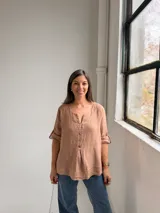 Blusa de lino color camel, con escote en V y botones frontales, de manga 3/4 con tiras ajustables en los puños y diseño holgado.