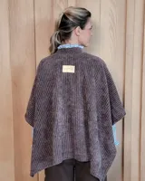 Ruana abierta de tejido de punto acanalado en color beige, con diseño holgado y caída fluida.