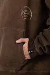 Buzo tipo canguro con capucha, de corte oversize y confeccionado en frisa rústica con efecto lavado. Presenta bolsillo frontal tipo canguro y estampado con texto en el pecho.