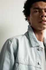 Cazadora de denim de algodón con corte regular fit, cuello solapa, cierre frontal con botones y bolsillos de vivo en la cadera. Presenta un acabado con efecto lavado.