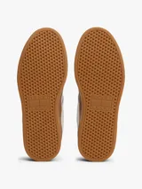 Zapatillas de corte bajo inspiradas en el baloncesto, con exterior de piel blanca, detalles en azul claro y suela de plataforma color caramelo. Presentan paneles de texturas a contraste y logo de la marca en el lateral.