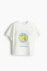 Remera de corte oversized confeccionada en punto de algodón, con cuello redondo y mangas cortas. Presenta un estampado frontal con motivos de limones y texto en italiano.