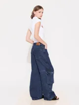 Pantalón de jean azul oscuro, corte wide leg con tiro medio y bolsillos cargo.