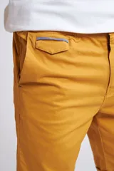 Bermuda tipo chino de gabardina, con cierre y botón frontal, bolsillos laterales y traseros, y dobladillo en el ruedo.