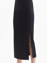 Pollera midi negra de canalé con cintura elástica y tajo lateral en el dobladillo.