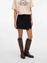 Pollera short de tiro alto y fit holgado, con diseño envolvente en la parte delantera y cierre lateral invisible.