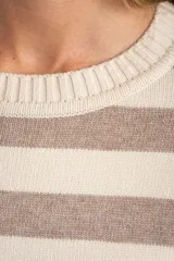 Sweater de punto con diseño a rayas horizontales en color negro y crema. Presenta cuello redondo, mangas largas con puños acanalados y un detalle de borde en tono bronce metalizado en el ruedo y los puños.