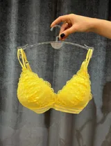 Bralette de encaje amarillo brillante con bordes festoneados y tirantes finos ajustables.