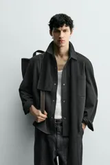 Sobrecamisa de corte regular fit en tejido elástico y transpirable, con cuello solapa, cierre frontal mediante botones a presión y bolsillo de plastrón en el pecho. Presenta mangas largas con puños abotonados y bajo con aberturas laterales.