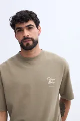 Remera de manga corta color verde militar con textura sutil y pequeña estampa discreta en el pecho.