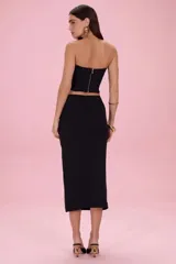 Top strapless negro con escote corazón y detalles de apliques de resina en tonos tostado y negro a lo largo del borde superior.