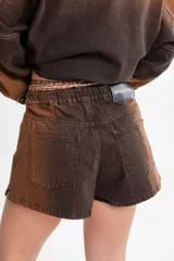 Short de jean azul con cintura elástica y cordón blanco con letras rojas.