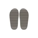 Chancletas Yeezy Slides de una sola pieza, color gris, con diseño minimalista, suela dentada y plantilla texturizada para mayor comodidad.