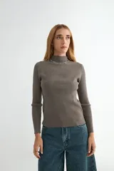 Polera de tejido de punto acanalado en color gris oscuro, con cuello alto y mangas largas ajustadas.