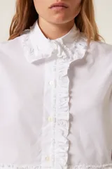 Camisa blanca de popelina con volados en cuello, puños y pechera.