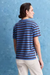 Remera de calce relajado con diseño a rayas horizontales blancas y verdes, hombros caídos y mangas amplias con vuelta. Presenta cuello redondo y ruedo trasero levemente más largo.