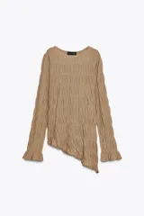 Top de manga larga color beige, con textura fruncida en todo el cuerpo y mangas. Presenta cuello redondo y bajo asimétrico con aberturas laterales ajustables con cordones.