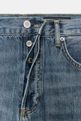 Pantalón de jean celeste de tiro medio, corte ancho y terminación con dobladillo.