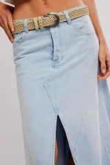 Falda larga de denim, de tiro medio y línea A, con abertura frontal, paneles con costuras y ruedo deshilachado en punta.