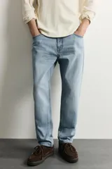 Jeans de corte slim cropped confeccionados en denim de algodón rígido con efecto lavado. Presentan tiro medio, cierre frontal con cremallera y botón, y diseño clásico de cinco bolsillos.