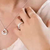 Anillo en forma de V fabricado en plata 925, con engaste de pequeñas circonias brillantes a lo largo de la banda.