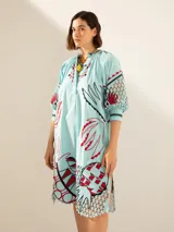 Túnica celeste con estampado de motivos botánicos en rojo y negro.