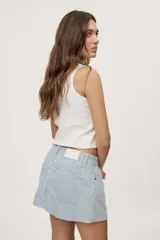 Falda corta de jean con diseño a rayas verticales celestes y blancas. Presenta tiro medio, bolsillos delanteros, pasadores en la cintura y cierre frontal con botón metálico.