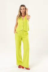 Chaleco verde lima de lino con lurex, escote en V, sin mangas y cierre frontal con botones.