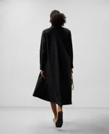 Vestido camisero midi negro de algodón, lyocell y poliéster, con cuello tira, manga larga y botonadura frontal oculta.