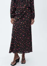 Falda midi evasé de viscosa color negro con estampado floral rojo.